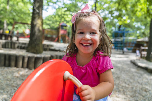 Porträt eines glücklichen kleinen Mädchens, das auf dem Spielplatz Spaß hat - MGIF00935