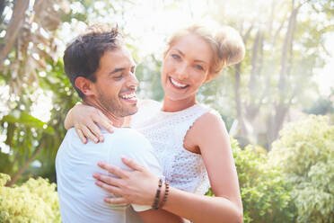 Porträt lächelnd junges Paar umarmt im Park - CAIF27217