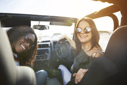 Porträt lächelnd junge Frauen Freunde tragen Sonnenbrille in sonnigen Jeep - CAIF27239