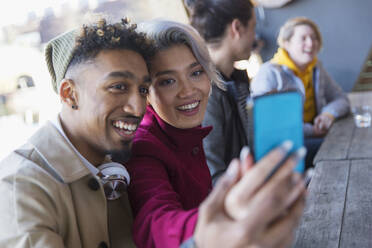 Smiling young couple taking selfie in camera phone - CAIF27255