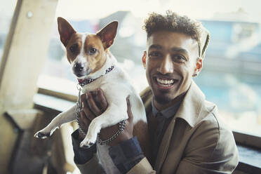 Porträt lächelnder junger Mann mit Hund - CAIF27256