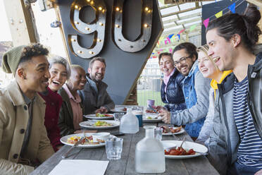 Fröhliche Freunde beim Frühstück im Innenhof des Restaurants - CAIF27260