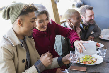 Smiling young couple dining at restaurant outdoor cafe - CAIF27267