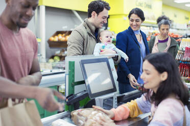 Kassiererin hilft Kunden an der Supermarktkasse - CAIF27333