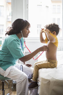 Eine Kinderärztin hört in einer Klinik den Herzschlag eines Jungen ab - MASF18028