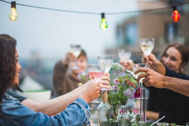 Young friends toasting drinks during social gathering on building terrace - MASF18218