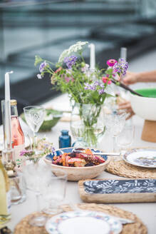 Schüssel mit Essen auf dem Tisch während einer Party auf der Terrasse eines Gebäudes - MASF18266