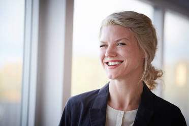 Smiling confident businesswoman looking away at workplace - MASF18279