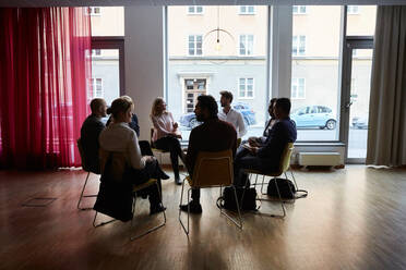 Männliche und weibliche Unternehmer sitzen im Kreis am Arbeitsplatz - MASF18300