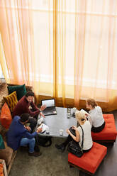 Blickwinkel von männlichen und weiblichen Unternehmern, die an einem Tisch in einem Büro-Workshop sitzen und diskutieren - MASF18329