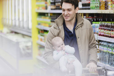 Vater und kleine Tochter beim Einkaufen im Supermarkt - CAIF27364