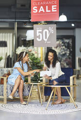 Frauen mit digitalem Tablet beim Einkaufen in einem Geschäft für Wohnkultur - CAIF27381
