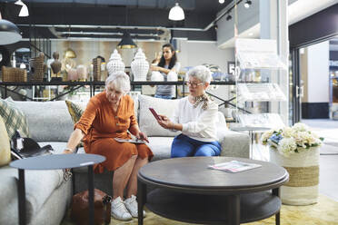 Ältere Frauen kaufen ein Sofa in einem Einrichtungsgeschäft - CAIF27390