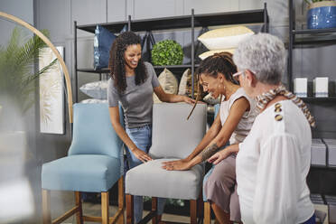 Frauen beim Einkaufen von Esszimmerstühlen im Home Decor Shop - CAIF27414