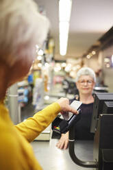 Kunde zahlt mit Smartphone an der Supermarktkasse - CAIF27458