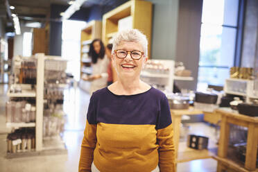 Porträt einer glücklichen älteren Frau beim Einkaufen in einem Haushaltswarengeschäft - CAIF27473