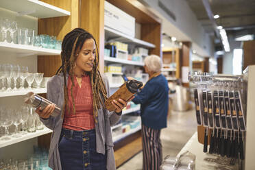 Woman shopping for insulated drink container in home goods store - CAIF27475