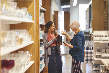 Worker helping woman shopping in home goods store - CAIF27487