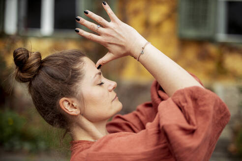 Porträt einer Frau, die im Freien Yoga praktiziert - DAWF01404