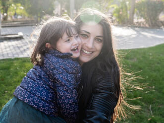 Portrait of happy little girl face to face with her mother outdoors - EGAF00050