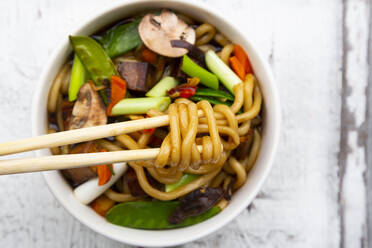 Schüssel mit japanischer Miso-Suppe mit Udon-Nudeln, Tofu, Zuckerschoten, Paprika, Karotten, Mu-err-Pilzen, Frühlingszwiebeln und Koriander - LVF08870