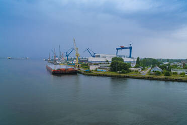 Germany, Mecklenburg-Western Pomerania, Rostock, Commercial dock on gray day - TAMF02218