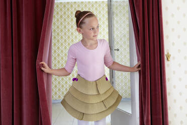 Girl wearing cardboard tutu looking around - AUF00402