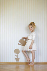 Portrait of girl playing with cardboard watering can and flower - AUF00420