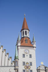 Deutschland, Bayern, München, Niedriger Blickwinkel auf den Uhrenturm des Alten Rathauses vor blauem Himmel - MMAF01328