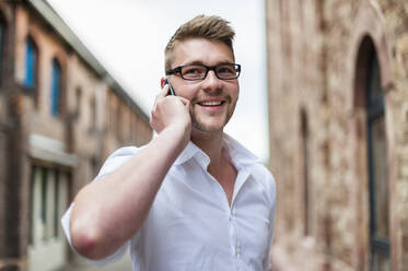 Portrait of a happy young businessman on the phone - DIGF10423