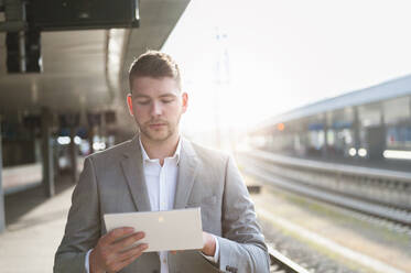 Young businessman using tablet at the train station - DIGF10447