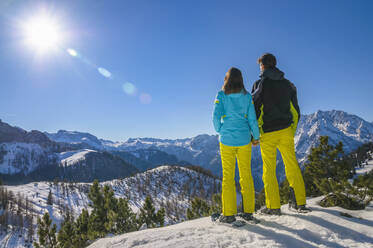 Rückansicht eines Paares beim Schneeschuhwandern am Jenner mit Blick auf die Landschaft - DIGF10458