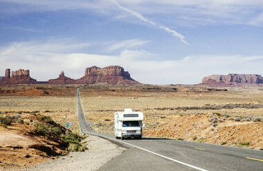 Wohnmobil fährt auf Wüstenstraße im Monument Valley Tribal Park gegen den Himmel, Utah, USA - DGOF00973