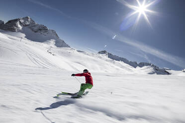 Deutschland, Bayern, Garmisch-Partenkirchen, Sonne scheint über Mann beim Skifahren auf der Zugspitze - WFF00412