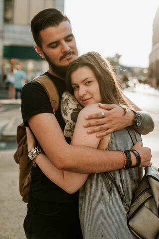 Glückliches junges Paar, das sich in der Stadt umarmt, Berlin, Deutschland, lizenzfreies Stockfoto