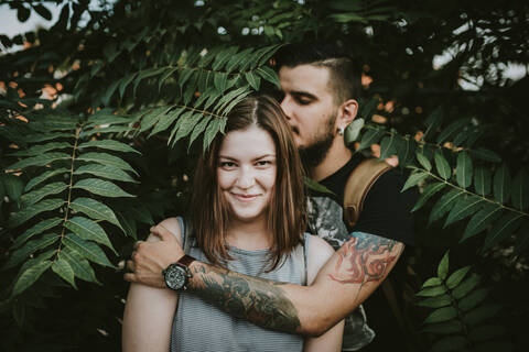 Porträt eines zärtlichen jungen Paares im Gebüsch, lizenzfreies Stockfoto