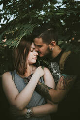 Affectionate young couple in shrubbery - VBF00019