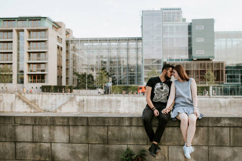 Junges Paar sitzt auf einer Mauer am Flussufer, Berlin, Deutschland - VBF00021
