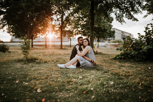 Junges Paar sitzt bei Sonnenuntergang im Park - VBF00029