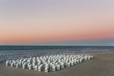 Hooded chairs at beach against sky during sunset, Ruegen, Germany - DIGF10485