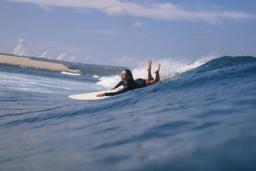 Woman surfing in the sea, Bali, Indonesia - KNTF04595