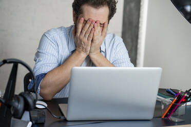 Exhausted man with laptop at home - VPIF02420