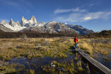 Man walking on boardwalk in front of Mount Fitz Roy in Autumn, El Chalten, Patagonia, Argentina - LOMF01091