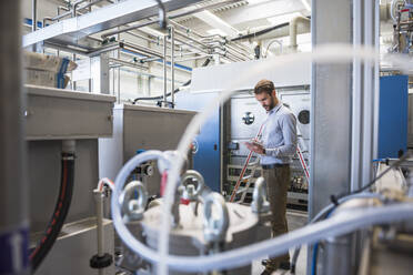 Geschäftsmann mit Tablet in einer Fabrik - DIGF10488