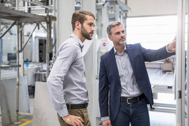 Two businessmen having a meeting in a factory - DIGF10496