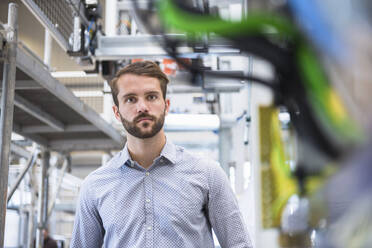 Porträt eines jungen Geschäftsmannes in einer Fabrik - DIGF10510