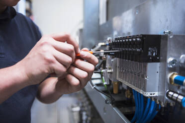 Close-up of man working at a circuitry in a factory - DIGF10520