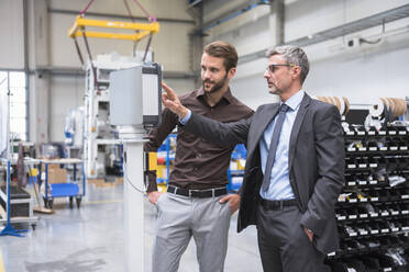 Two businessmen talking in a factory - DIGF10526