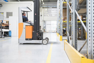 Worker on forklift in high rack warehouse - DIGF10587