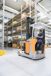Worker on forklift in high rack warehouse - DIGF10588